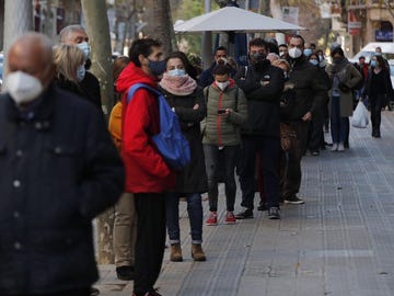 Numerosas personas hacen cola para hacerse test de antígenos en un laboratorio privado de Barcelona.