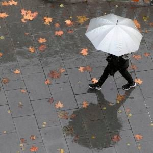 Una persona camina bajo la lluvia Una persona camina bajo la lluvia